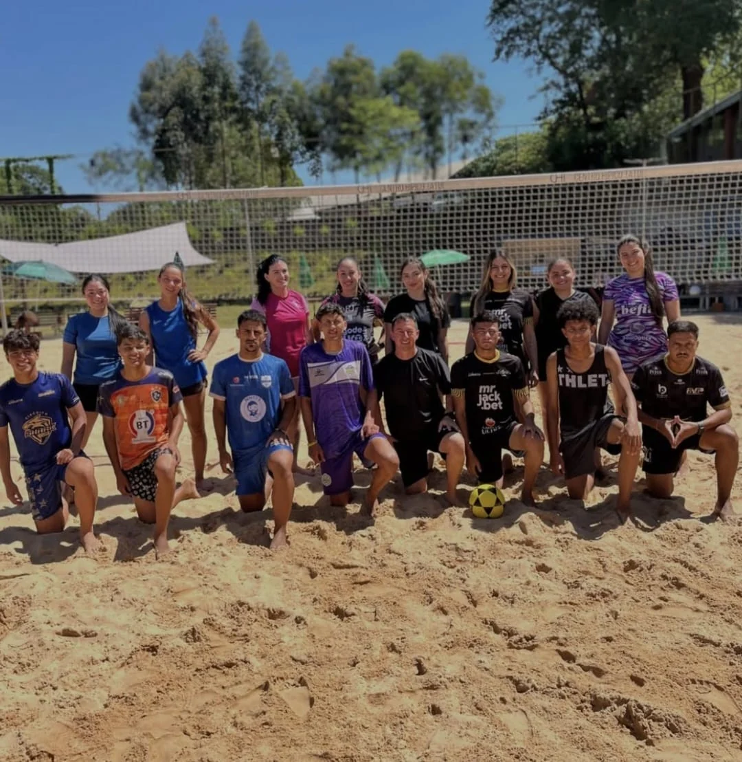 Grupo de alunos da Arena CHT reunidos na quadra de areia após o treino